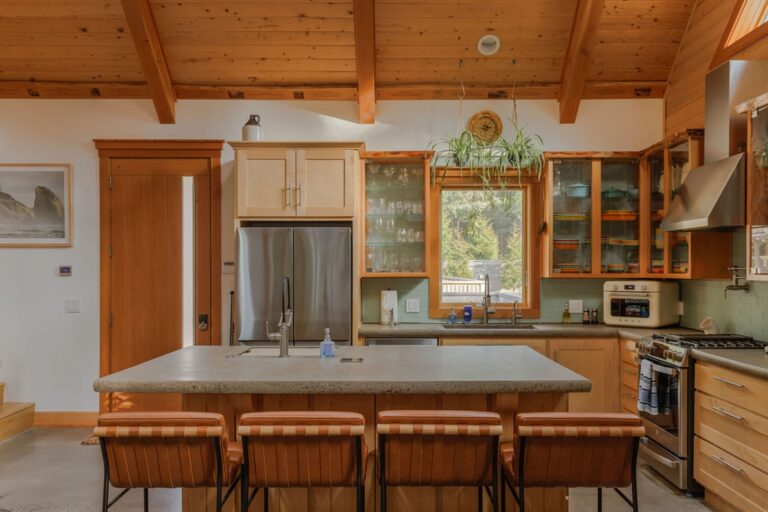 Kitchen has 2 sinks and a cabinet filled with speciality glassware (wine, champagne, beer, spirits, cocktail)