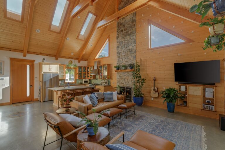 Spacious great room featuring a vaulted ceiling and a floor to ceiling gas fireplace